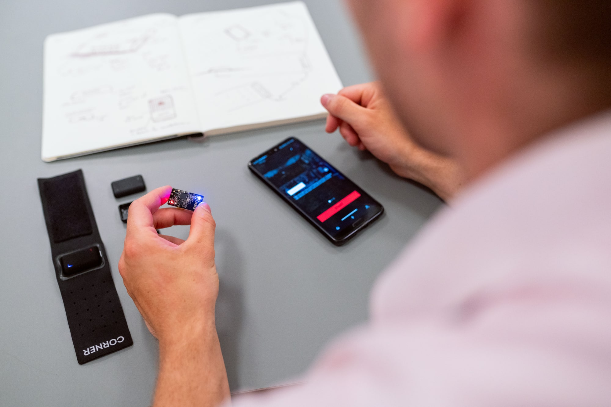 Engineer testing a smartphone application with connected prototype hardware